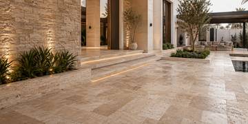 Natural stone floor and wall installation in a Dubai villa courtyard transition space